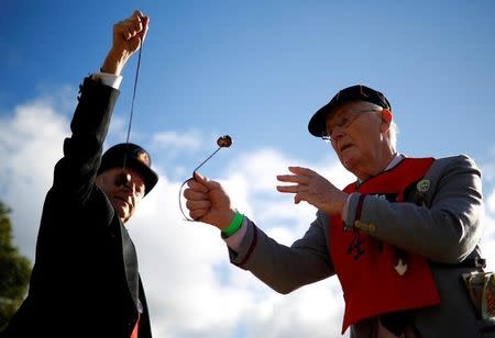 Competitors swing their conkers during a match at the World Conker Championships, in Southwick, central England October 9, 2016. REUTERS/Phil Noble