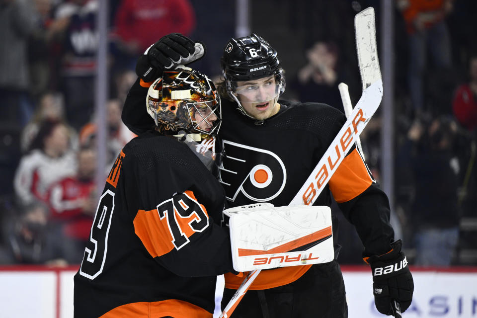 Philadelphia Flyers goaltender Carter Hart, left, and Travis Sanheim celebrate their team's victory against the Washington Capitals, Saturday, Feb. 26, 2022, in Philadelphia. The Flyers won 2-1. (AP Photo/Derik Hamilton)