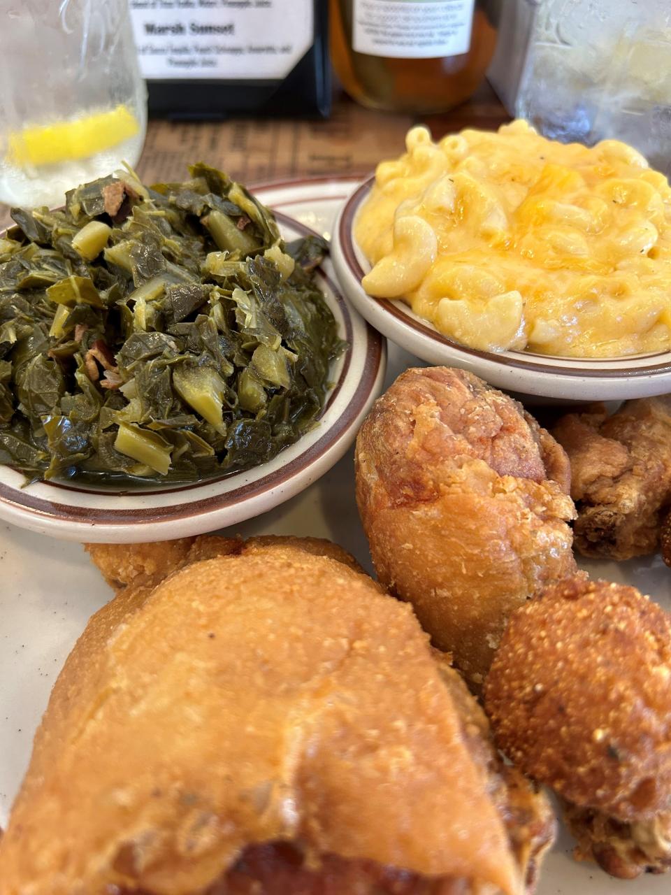 The Marsh Landing menu warns diners: The fried chicken will take 20 minutes. It's worth the wait. The chicken is shown here with hushpuppies, macaroni and cheese and turnip greens.