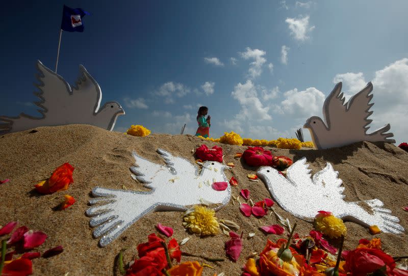 A girl prays during a prayer ceremony for the victims of the 2004 tsunami on the 15th anniversary of the disaster, in Chennai