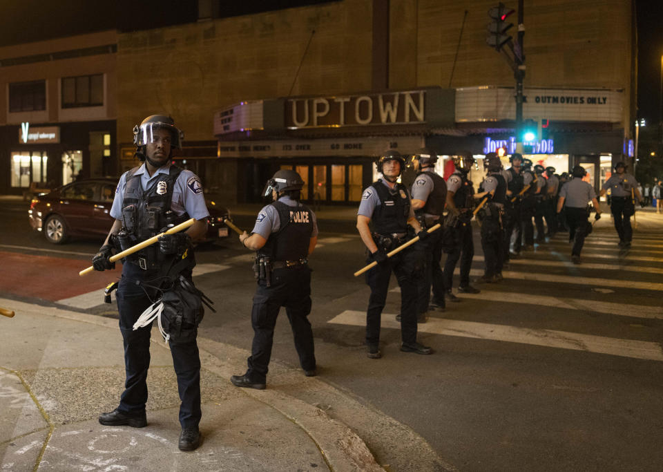 Minneapolis police officers stand in formation after a vigil for Winston Boogie Smith Jr. early on Saturday, June 5, 2021. Authorities say Smith, wanted on a weapons violation, fired a gun from inside his vehicle before he was fatally shot by members of a federal task force as they were trying to arrest him. (AP Photo/Christian Monterrosa)