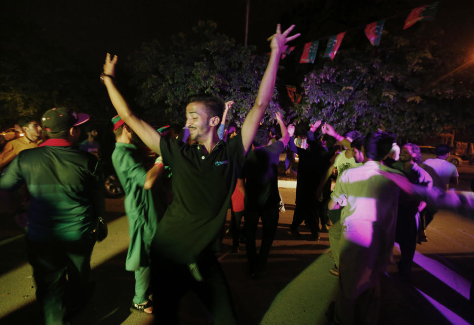 FILE - Supporters of Pakistani politician Imran Khan, chief of Pakistan Tehreek-e-Insaf party, dance to celebrate projected unofficial results announced by television channels indicating their candidates' success in the parliamentary elections, in Islamabad, Pakistan, July 26, 2018. Pakistan is holding elections for a new parliament on Thursday, Feb. 8, 2024 Forty-four political parties are vying for a share of the 266 seats that are up for grabs in the National Assembly, or the lower house of parliament. (AP Photo/Anjum Naveed, File)