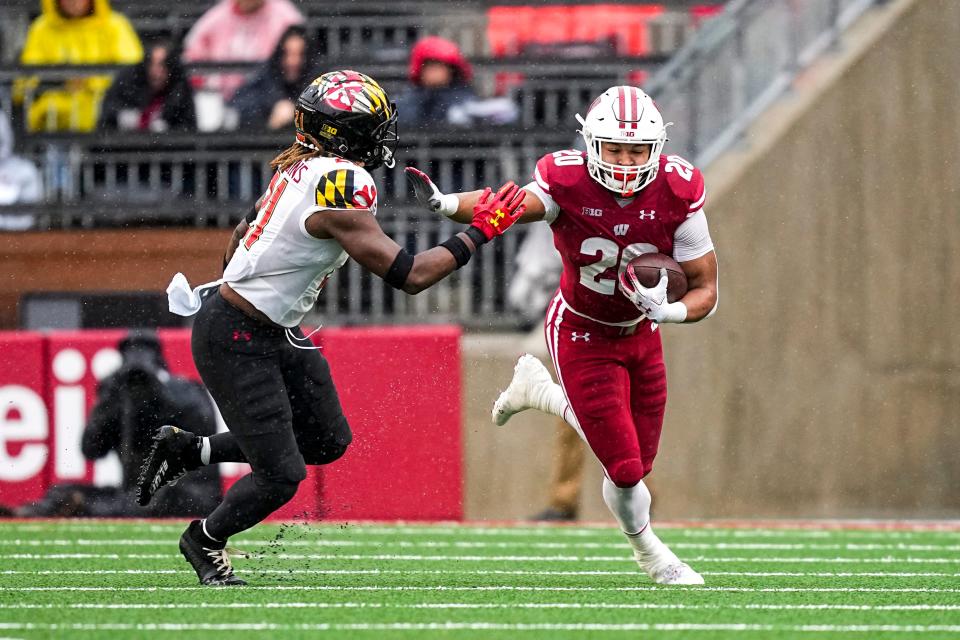 Wisconsin running back Isaac Guerendo (20) runs against Maryland linebacker Gereme Spraggins (21) during the first half of an NCAA college football game Saturday, Nov. 5, 2022, in Madison, Wis. (AP Photo/Andy Manis)