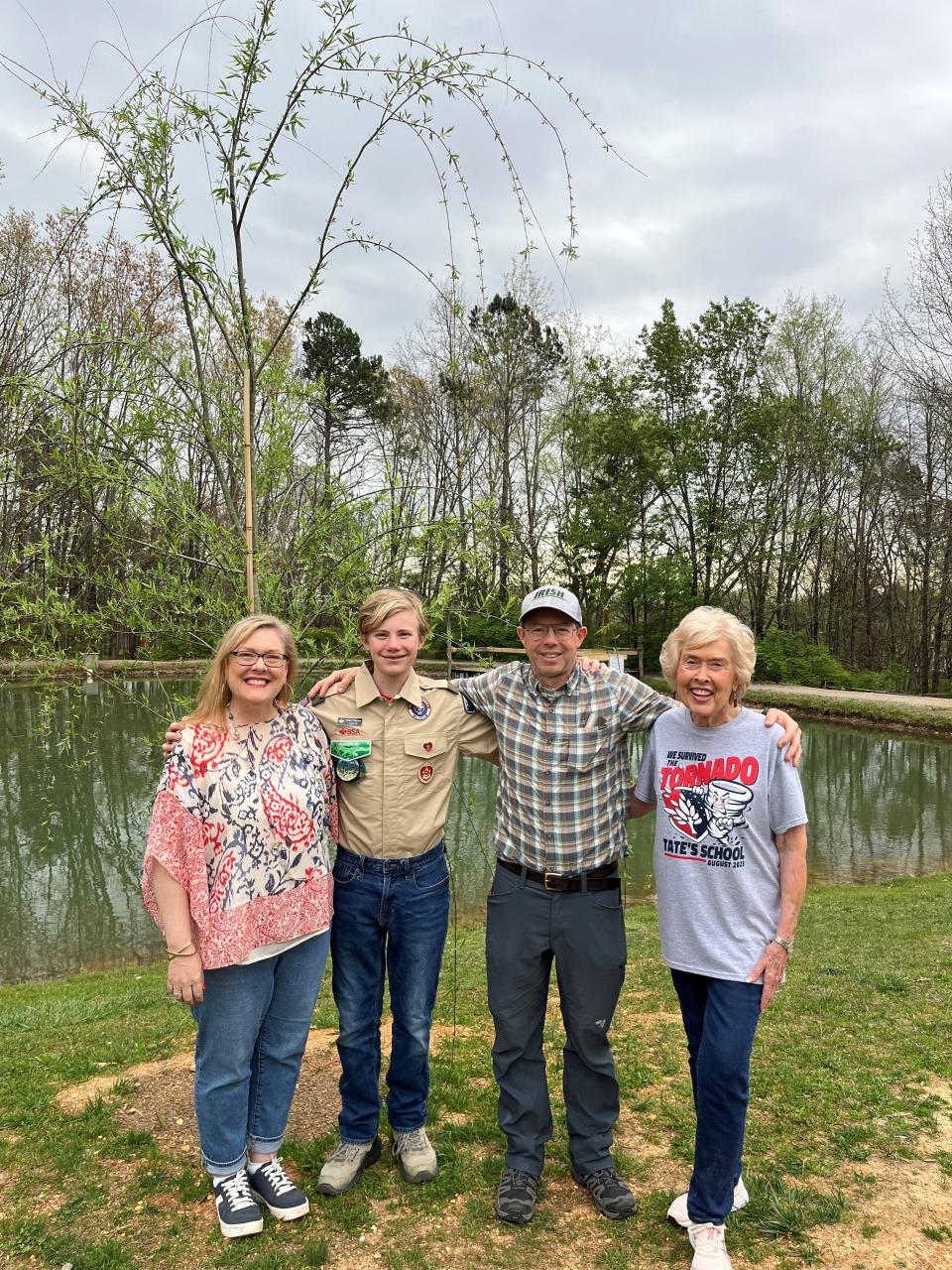 Former Tate’s School student William Patterson stands near a planted willow tree by the school’s pond with Tate’s School director of resources Tracey Van Hook, left, father Phillip Patterson, and CEO and school founder LouL Tate.