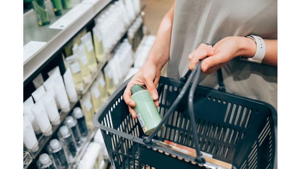 An anonymous female customer holding her basket while shopping