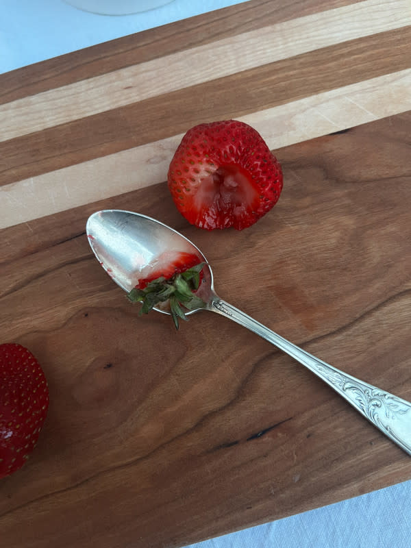 Using a teaspoon to hull a strawberry<p>Courtesy of Jessica Wrubel</p>