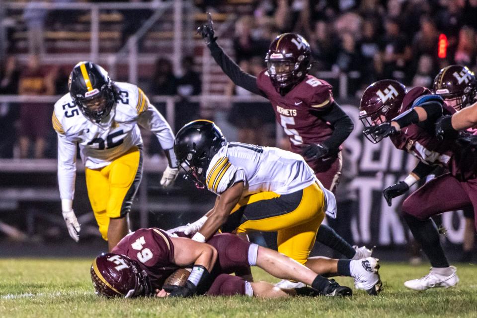 Licking Heights players celebrate a fumble recovery for Ethan Whitt (64) during last Friday’s game against Watkins Memorial. D’Angelo Goodrich (5) later left with an injury.