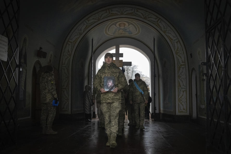 Soldiers carry the coffin of Ukrainian serviceman and famous Ukrainian poet Maksym Kryvtsov, who was killed in a battle with the Russian troops, during the funeral ceremony in St. Michael Cathedral in Kyiv, Ukraine, Thursday, Jan. 11, 2024. (AP Photo/Efrem Lukatsky)