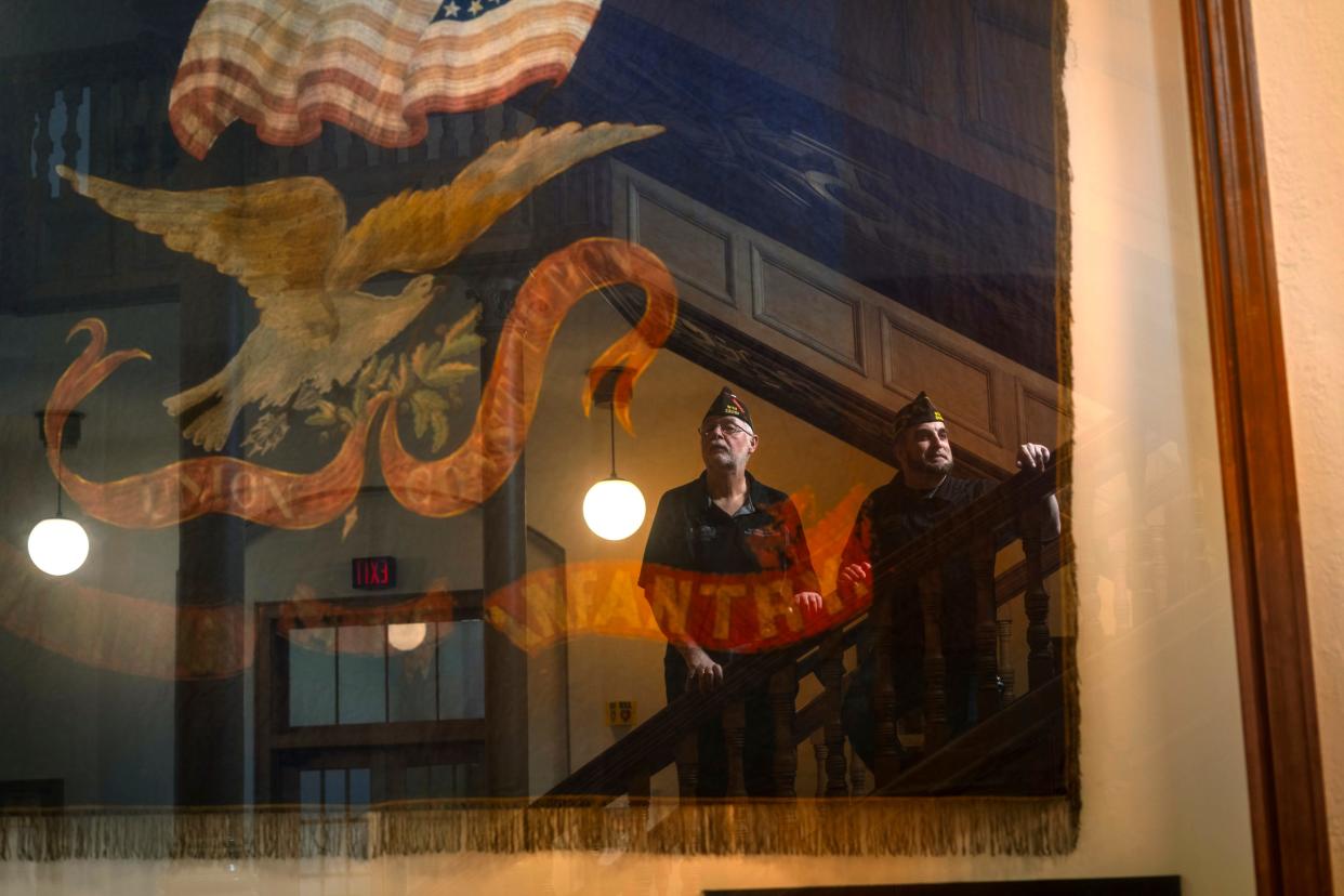 Ionia VFW Post 12082 quartermaster Shane Houghton, left, and Marine Cpl. Eric Calley of Williamston are reflected in the glass of a case that holds a Civil War battle flag carried by the 21st Michigan Infantry, which hangs inside the Ionia County Courthouse, as seen on Tuesday, Feb. 27, 2024. The two men have led an effort to restore the flag and keep it on public display in the courthouse.
