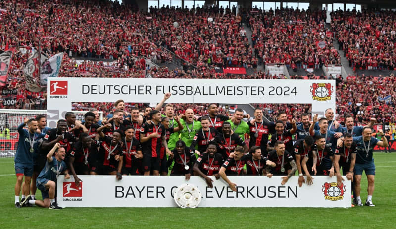 Leverkusen players celebrate with the championship trophy following the German Bundesliga soccer match between Bayer Leverkusen and FC Augsburg at BayArena. Federico Gambarini/dpa