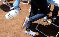 A World Health Organization (WHO) worker sprays her shoes with chlorine as she prepares a centre for vaccination during the launch of a campaign aimed at beating an outbreak of Ebola in the port city of Mbandaka, Democratic Republic of Congo May 21, 2018. REUTERS/Kenny Katombe