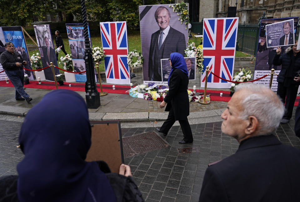 Members of the Anglo-Iranian communities and supporters of the National Council of Resistance of Iran hold a memorial service for British MP David Amess outside the Houses of Parliament in London, Monday, Oct. 18, 2021. British lawmaker David Amess was killed on Friday during a meeting with constituents at the Belfairs Methodist church, in Leigh-on-Sea, Essex, England. (AP Photo/Alberto Pezzali)