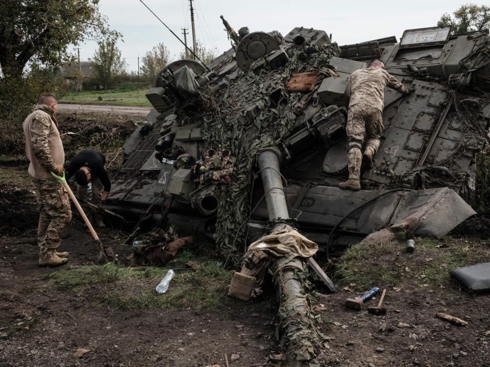 Ukrainian soldiers scavenge an abandoned Russian T-90A tank in Kyrylivka, in the recently retaken area near Kharkiv, on September 30, 2022.