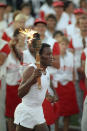 FILE - In this July 28, 1984, file photo, 1960 U.S. gold medal decathlete Rafer Johnson carries the Olympic torch through the Los Angeles Memorial Coliseum before lighting the Olympic flame and formally launching the 1984 summer games. Rafer Johnson died Wednesday, Dec. 2, 2020. He was 86. He died at his home in the Sherman Oaks section of Los Angeles, according to family friend Michael Roth. (AP Photo/Peter Leabo, File)