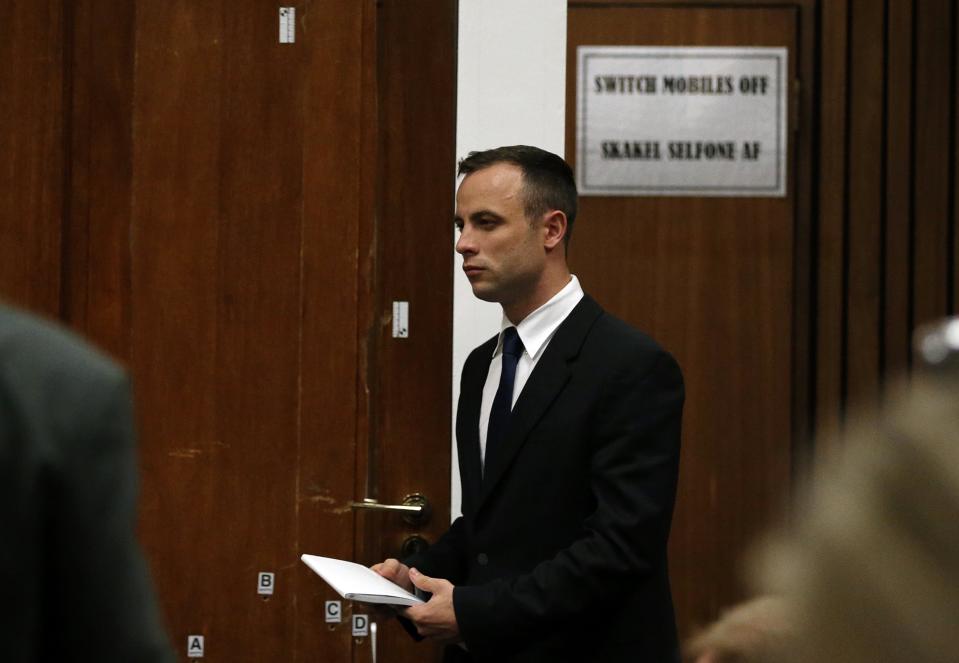 Olympic and Paralympic track star Oscar Pistorius walks past the door through which Reeva Steenkamp was shot, at the end of his trial at North Gauteng High Court in Pretoria April 15, 2014.The prosecutor in the murder trial of Pistorius ended his five-day cross-examination of the double amputee track star on Tuesday with a stark summary of how he shot his girlfriend, insisting he killed her deliberately after an argument. REUTERS/Siphiwe Sibeko (SOUTH AFRICA - Tags: SPORT ATHLETICS CRIME LAW)