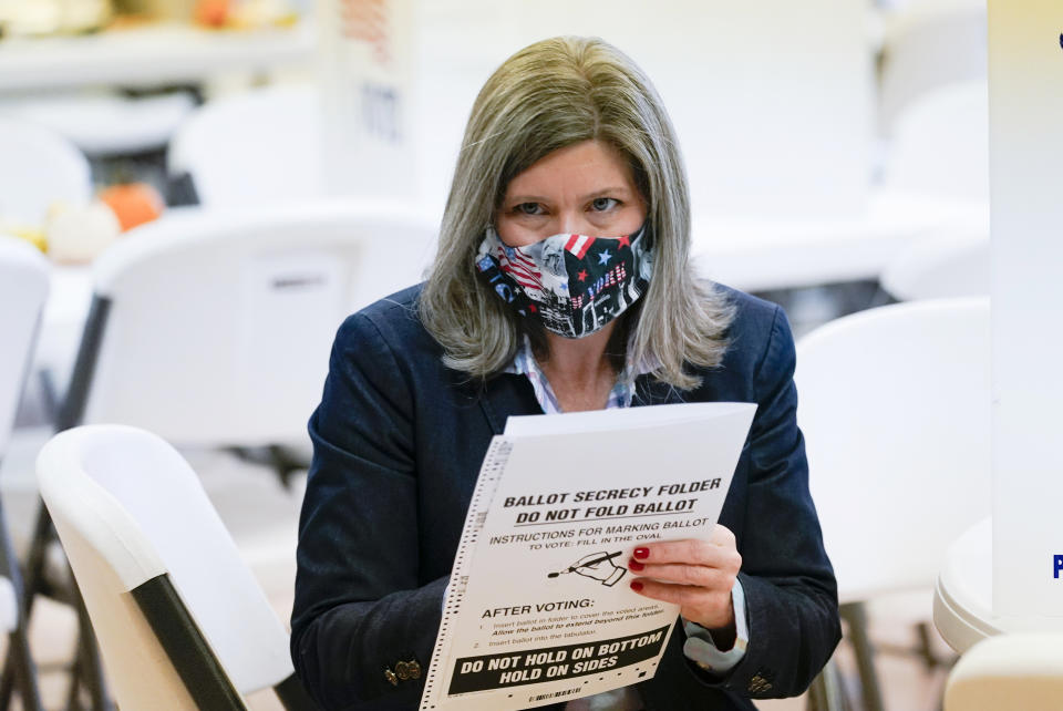 Republican Senate candidate Sen. Joni Ernst carries her ballot to the ballot box at Red Oak First Christian Church Tuesday, Nov. 3, 2020, in Red Oak, Iowa. (AP Photo/Charlie Neibergall)