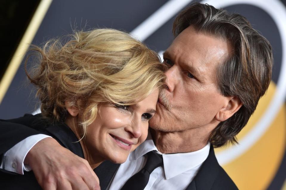 Kevin Bacon kissing Kyra Sedgwick on the forehead on a red carpet