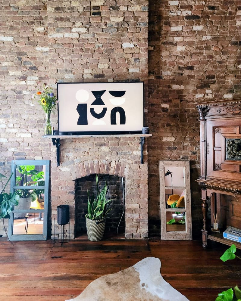 Television above fireplace mantel in newly renovated living room.