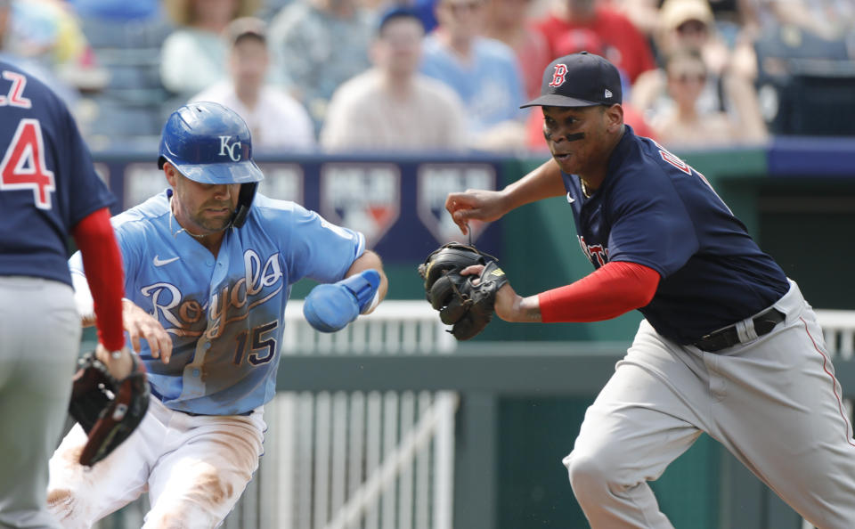 Kansas City Royals' Whit Merrifield, left, is chased down by Boston Red Sox third baseman Rafael Devers, right, for an out during a rundown between home plate and third base in the third inning of a baseball game at Kauffman Stadium in Kansas City, Mo., Saturday, June 19, 2021. (AP Photo/Colin E. Braley)