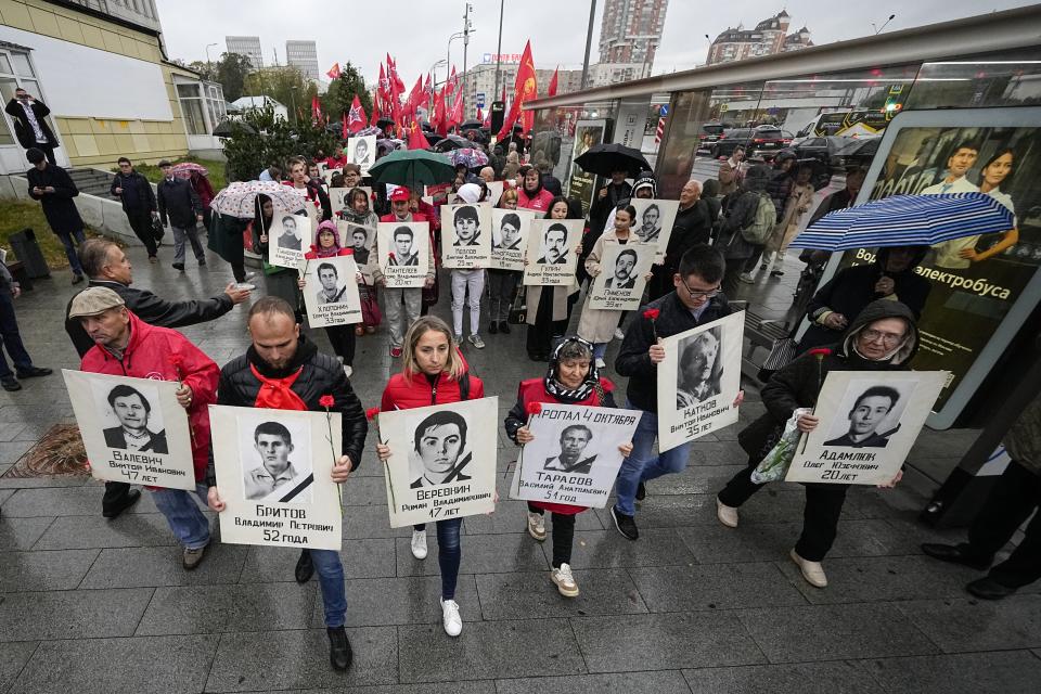 People march with flowers and portraits of those who were killed during the 1993 bloody clashes between government forces and supporters of the rebellious parliament during a rally marking the 30th anniversary of the events in Moscow, Russia, Wednesday, Oct. 4, 2023. The authorities said that 124 people died in the clashes on Oct. 3-4, 1993, but unofficial estimates suggested a higher death toll. (AP Photo/Alexander Zemlianichenko)