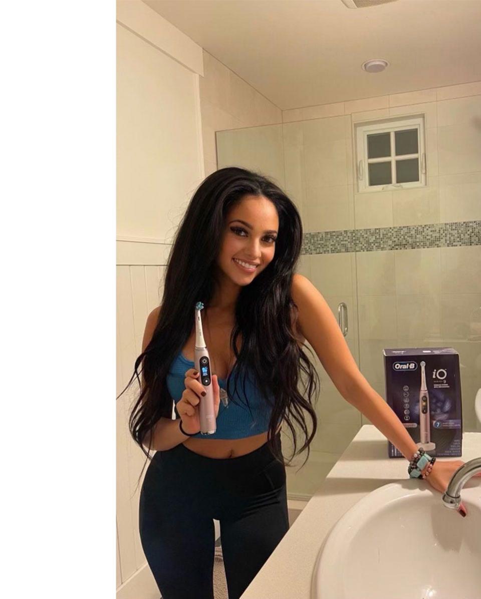 Vanessa Morgan posing with an Oral-B iO toothbrush.