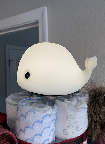 The small whale nightlight on top of some towels 