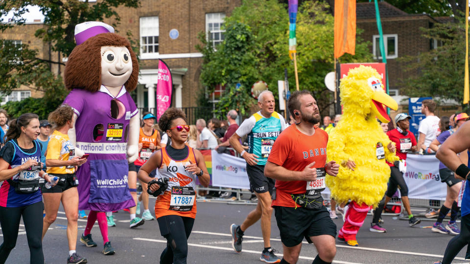  LONDON, UNITED KINGDOM - 2022/10/02: Some runners seen in fancy costumes as they run past mile 21 during the London marathon. For the first time a stretch of the London Marathon route was transformed into Rainbow Row to celebrate the LGBTQIA+ community, promote inclusivity and create a party atmosphere. Marathon runners passed two stages with music and drag performances. Butchers Row in Limehouse was covered with colourful flags and buntings. . 