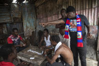 Jimmy Cherizier, aka Barbecue, a former policeman who leads the G9 gang coalition, visits with friends as they play a game of dominoes in the Cite Soleil shantytown of Port-au-Prince, Haiti, Sunday, Oct. 3, 2021. Despite all appearances, he says he is not positioning himself for a political career. He claims not to have any political affiliation or party and says he does not see himself "as a candidate in a system that I see as corrupt." (AP Photo/Rodrigo Abd)