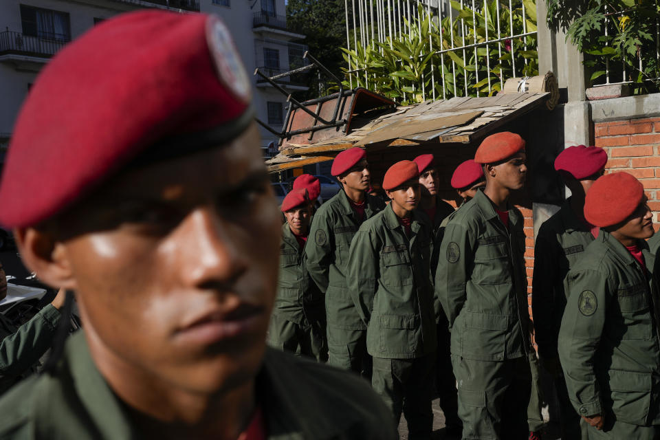 CORRECTS BYLINE TO MATIAS DELACROIX INSTEAD OF ARIANA CUBILLOS - Members of the Presidential Guard line up to vote in a referendum about the future of a disputed territory with Guyana, at a polling station in Caracas, Venezuela, Sunday, Dec. 3, 2023. (AP Photo/Matias Delacroix)