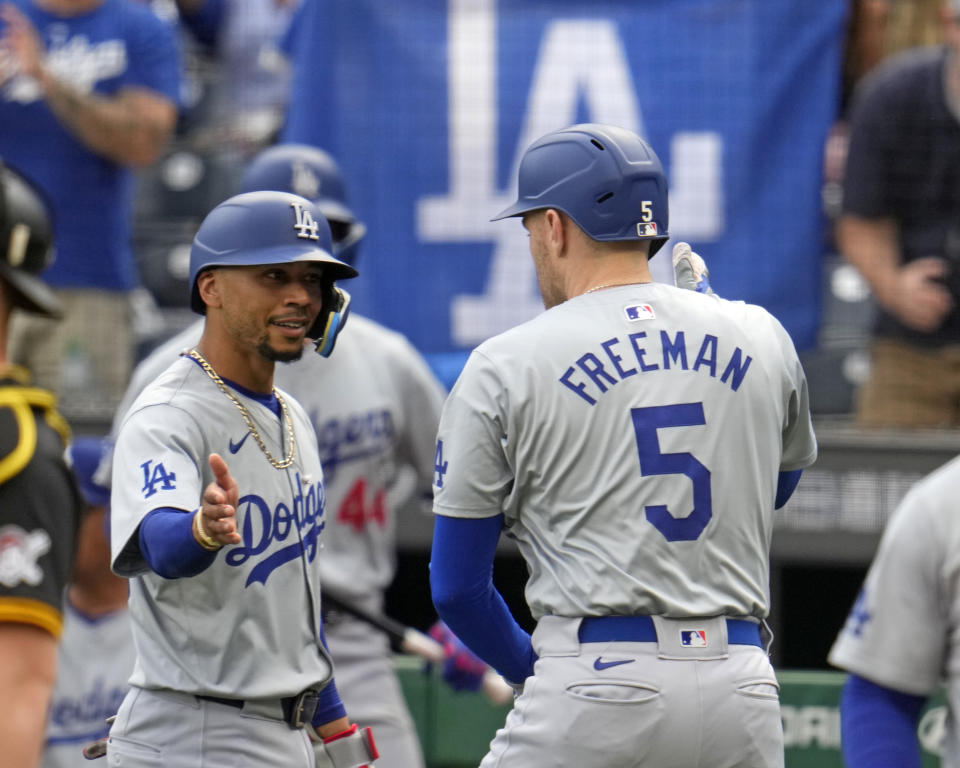 Los Angeles Dodgers' Freddie Freeman (5) is greeted by Mookie Betts, left, as he returns to the dugout after hitting a three-run home run off Pittsburgh Pirates starting pitcher Bailey Falter during the first inning of a baseball game in Pittsburgh, Thursday, June 6, 2024. (AP Photo/Gene J. Puskar)
