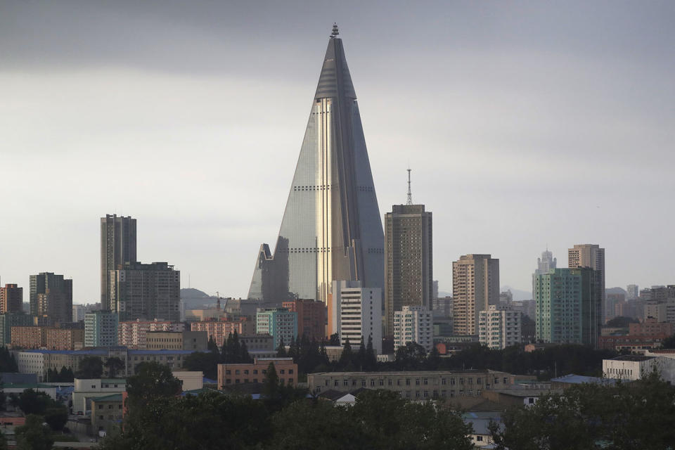 <p>The sky is overcast at the end of a workday on July 17, 2017, in Pyongyang, North Korea, where the 105-story pyramid-shaped Ryugyong Hotel is seen in this photograph towering over residential apartments. (Photo: Wong Maye-E/AP) </p>