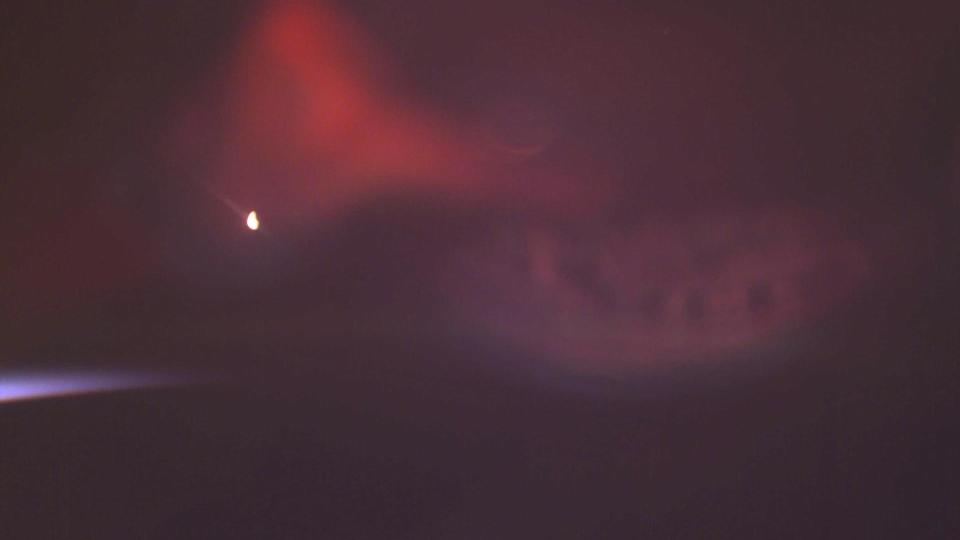 A photograph from the International Space Station of a red aurora