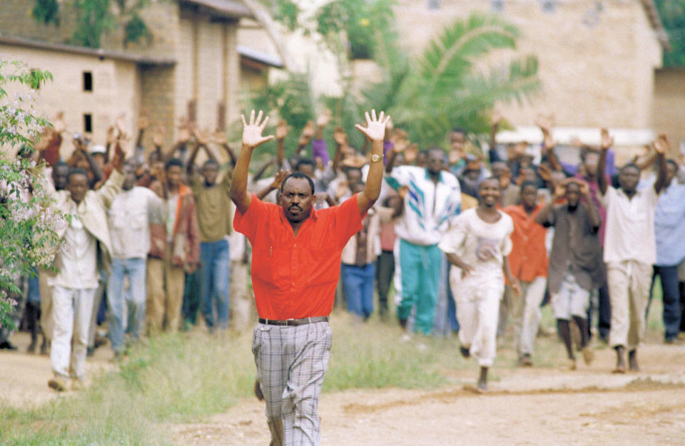 FILE - Rwandan refugees hold their hands up and ask for help from Belgian soldiers, who had come to a psychiatric hospital compound outside of Kigali on April 13, 1994. A frail 87-year-old Rwandan, Félicien Kabuga, accused of encouraging and bankrolling the 1994 genocide in his home country goes on trial Thursday, Sept. 29, 2022, at a United Nations tribunal, nearly three decades after the 100-day massacre that left 800,000 dead. (AP Photo/Karsten Thielker, File)