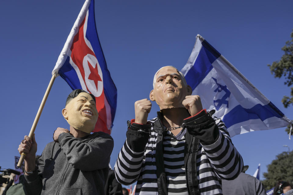 Protesters wear mask as Israeli Prime Minister Benjamin Netanyahu and North Korean leader Kim Jong Un during a protest against Benjamin Netanyahu's new government in front of Israel's Parliament in Jerusalem, Thursday, Dec. 29, 2022. Netanyahu was set to return to office Thursday at the helm of the most religious and ultranationalist government in Israel's history, vowing to implement policies that could cause domestic and regional turmoil and alienate the country's closest allies. (AP Photo/Oded Balilty)