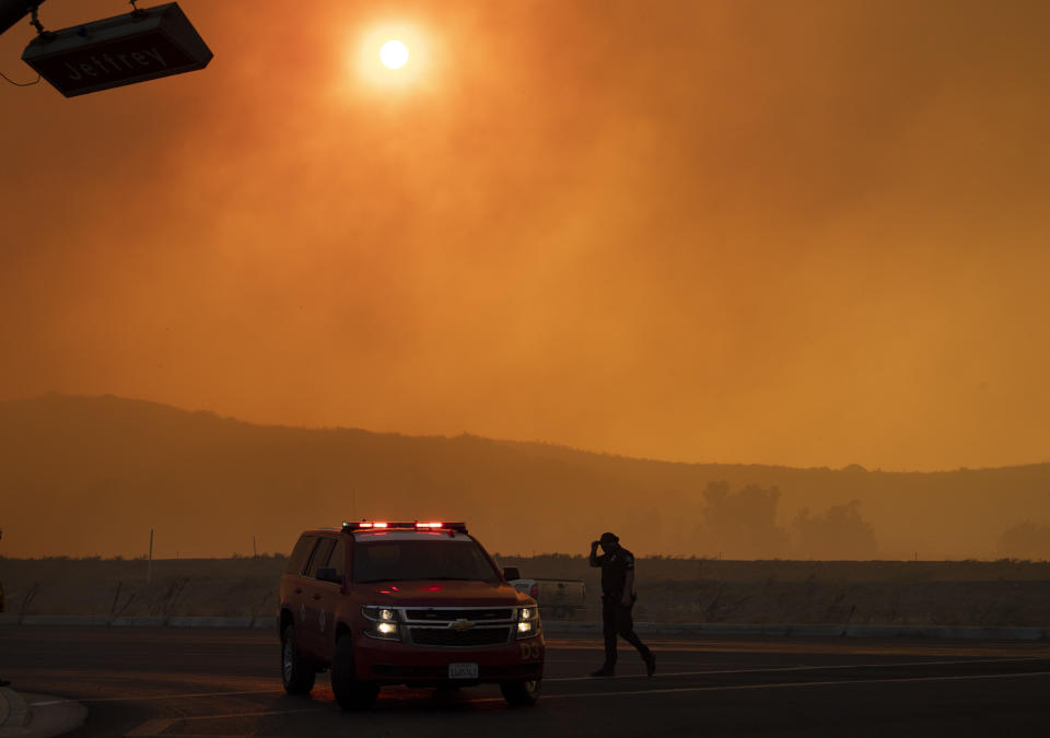 Police and firefighters are out in full force on Jeffrey and Portola in Irvine, Calif., where smoke fills the sky from the wind-driven Silverado wildfire on Monday, Oct. 26, 2020. (Mindy Schauer/The Orange County Register via AP)