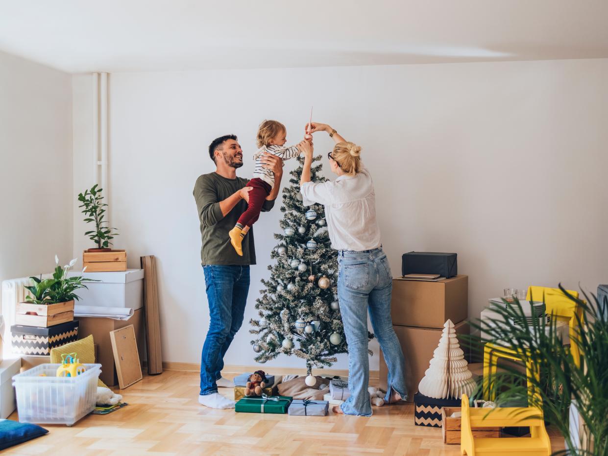 Happy Family Decorating Christmas Tree in New Home