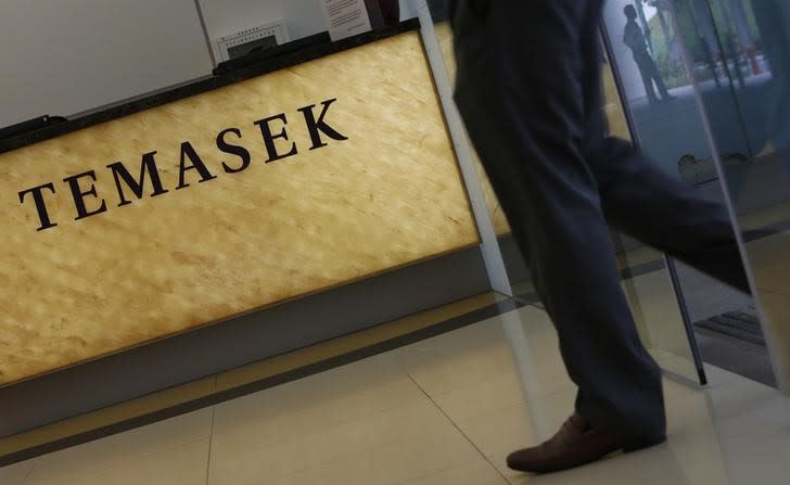 A man passes a logo of state investor Temasek Holdings at their office in Singapore July 8, 2014. REUTERS/Edgar Su