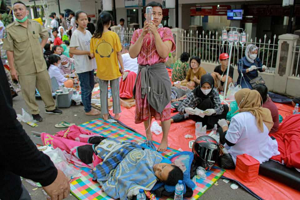 Earthquake survivors are treated outside of a hospital in Cianjur, West Java, Indonesia, Monday, Nov. 21, 2022. An earthquake shook Indonesia's main island of Java on Monday damaging dozens of buildings and sending residents into the capital's streets for safety. (AP Photo/Kholid)