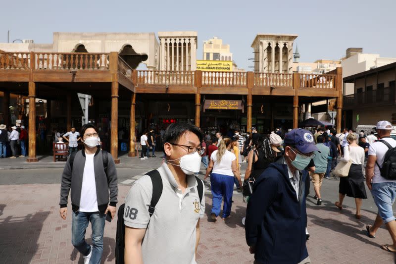 Tourists wear protective face masks, following the outbreak of the new coronavirus, as they walk at the Grand Souq in old Dubai