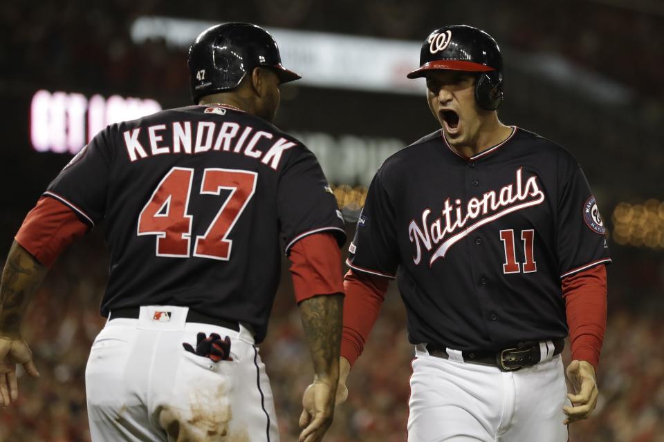 Washington Nationals' Ryan Zimmerman reacts with Howie Kendrick after scoring during the first inning of Game 4 of the baseball National League Championship Series against the St. Louis Cardinals Tuesday, Oct. 15, 2019, in Washington. (AP Photo/Jeff Roberson)