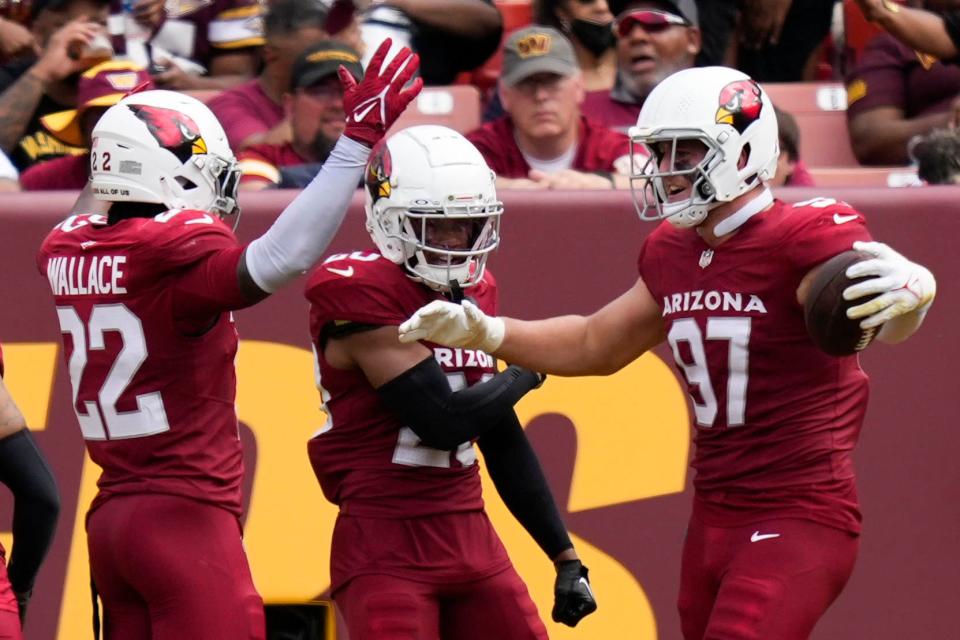 Arizona Cardinals safety K'Von Wallace (22) cornerback Marco Wilson (20) and linebacker Cameron Thomas (97) celebrate after scoring a touchdown against the Washington Commanders in the second half at FedExField on Sept. 10, 2023, in Landover, Maryland.