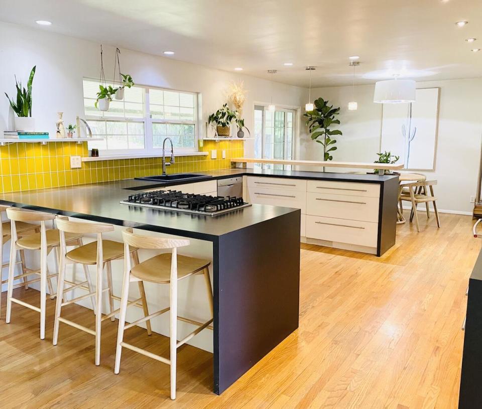 A shock of yellow tile anchors an open kitchen