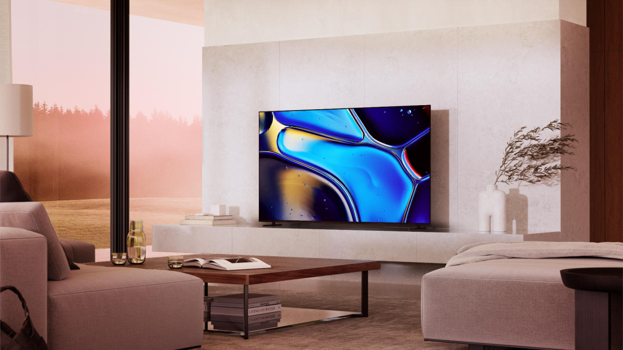  Sony Bravia 8 in a modern living room with beige furniture and a wooden coffee table. 