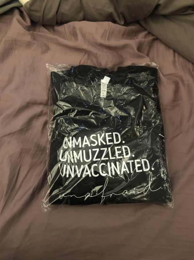 shirt says: unmasked, unmuzzled, unvaccinated