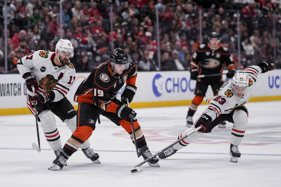 Anaheim Ducks right wing Troy Terry, center, vies for the puck against Chicago Blackhawks left wing Nick Foligno, left, and center Philipp Kurashev during the third period of an NHL hockey game Thursday, March 21, 2024, in Anaheim, Calif. (AP Photo/Ryan Sun)