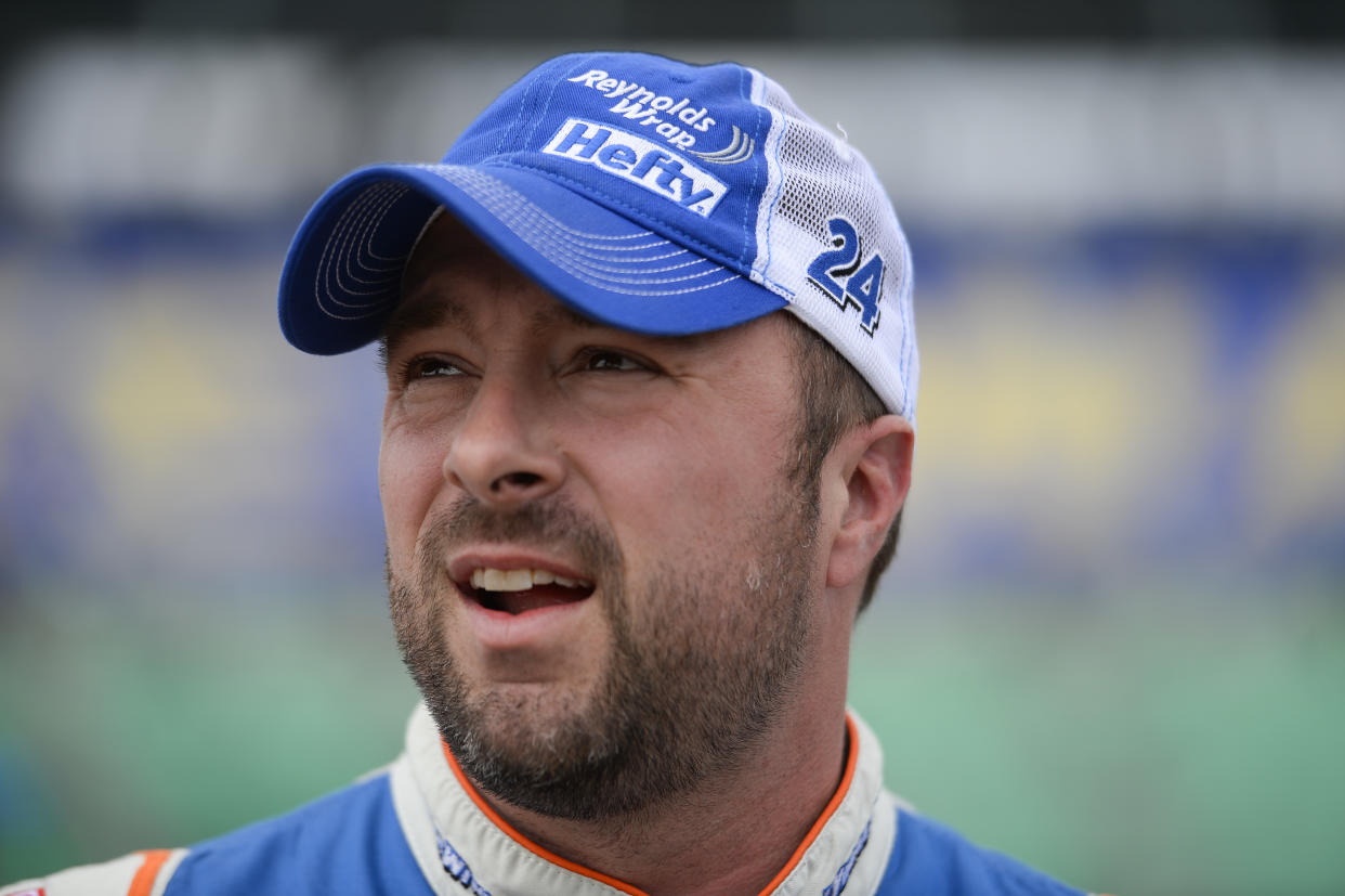 Eric McClure, driver of the #24 Reynolds Wrap Toyota, stands in the garage area during qualifying for the NASCAR XFINITY Series Kansas Lottery 300 at Kansas Speedway on October 17, 2015 in Kansas City, Kansas.