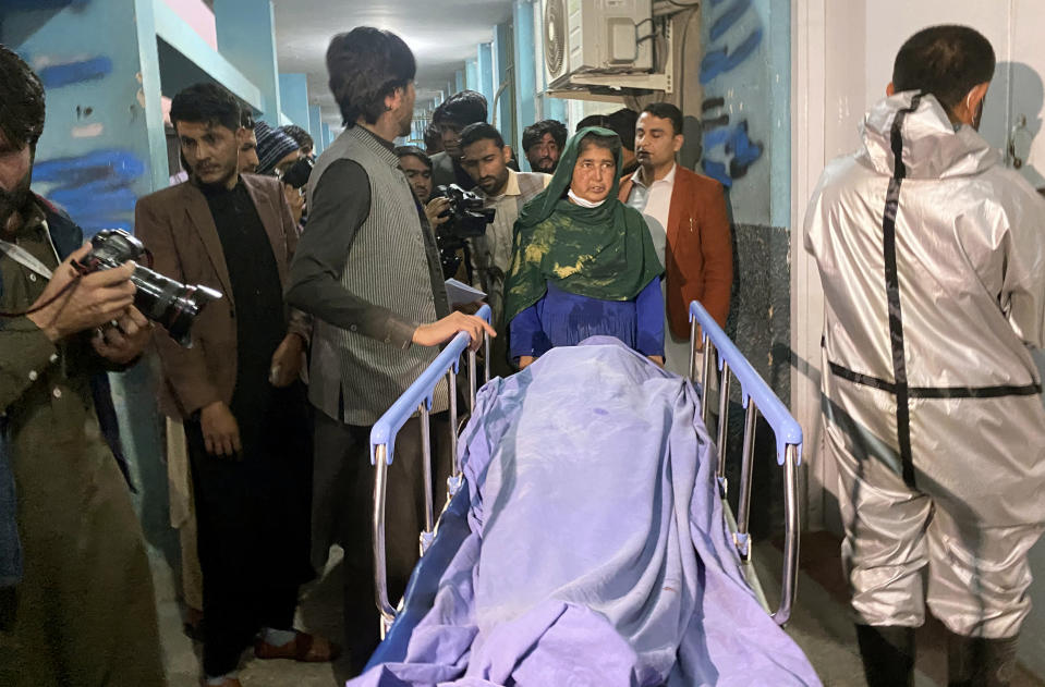 Afghans carry the body of a woman who was killed by gunmen in the city of Jalalabad east of Kabul, Afghanistan, Tuesday, March 2, 2021. Three women who worked for a local radio and TV station in eastern Afghanistan were gunned down Tuesday in two separate attacks, the news editor of the privately owned station said. (AP Photo/Sadaqat Ghorzang)