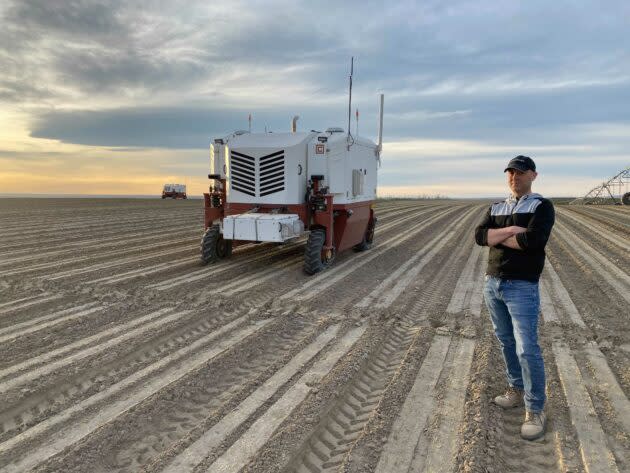 Carbon Robotics CEO Paul Mikesell in a farm field with his company’s autonomous weeder. The robot uses laser light to zap as many as 100,000 weeds an hour. (Carbon Robotics Photo)