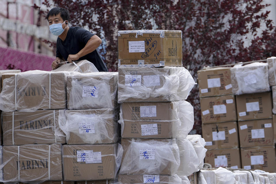 FILE - A worker loads boxes of goods from a truck outside a wholesale clothing mall in Beijing on Tuesday, June 14, 2022. Chinese factory activity rebounded in January from three months of contraction, adding to signs the world’s second-largest economy might be recovering from a painful slump, an official survey showed Tuesday, Jan. 31, 2023. (AP Photo/Andy Wong, File)