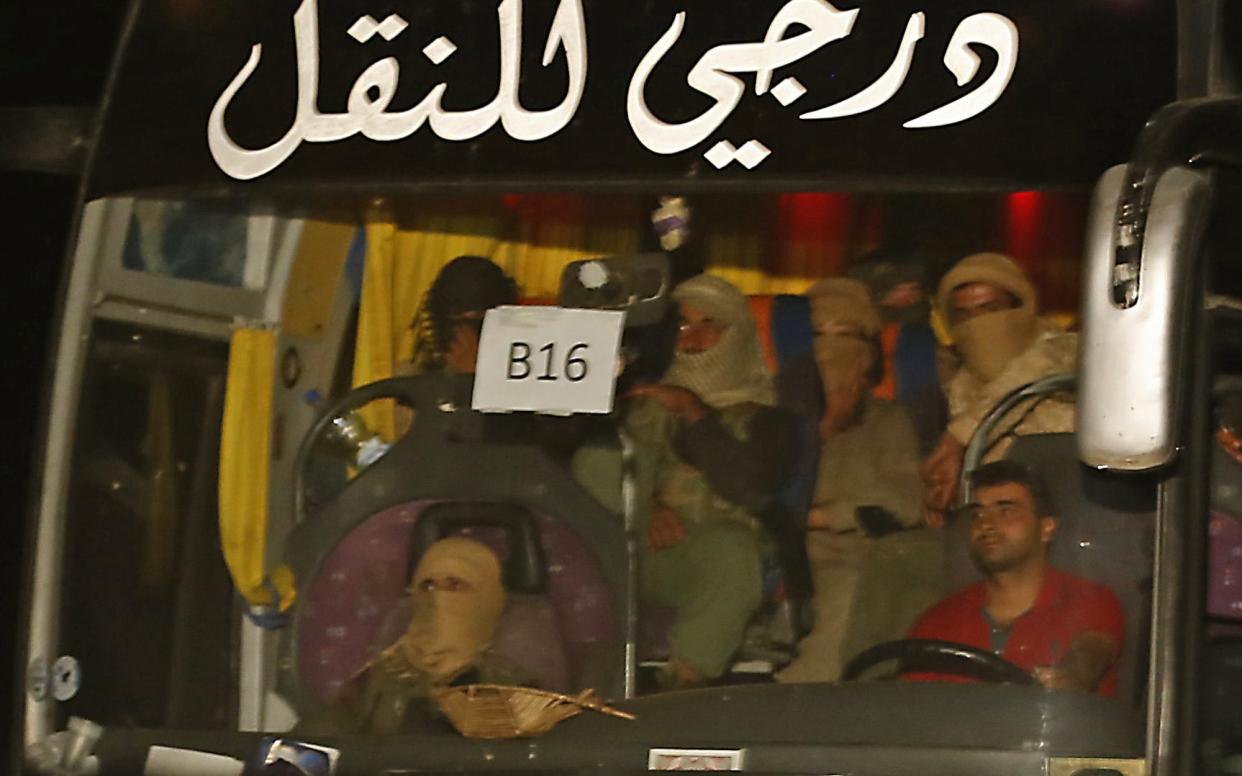 A bus carrying members of the Islamic State (Isil) group leaves the Qara area in Syria's Qalamoun region on August 28, 2017 as the jihadists are transported to Deir Ezzor as part of an unprecedented deal to end three years of jihadist presence. - AFP or licensors